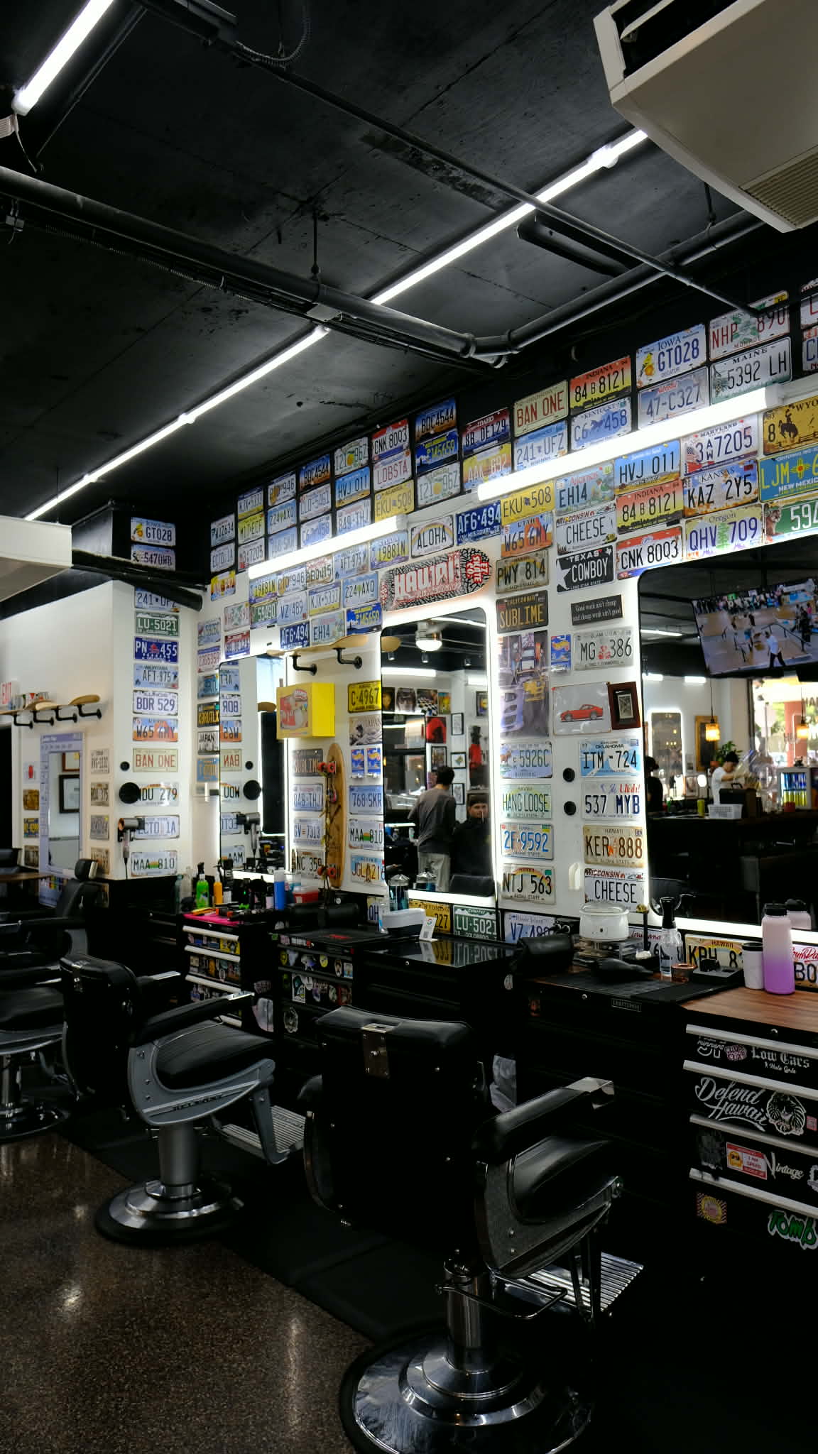 Vintage Barbershop interior Honolulu — barber chairs and license plate decor
