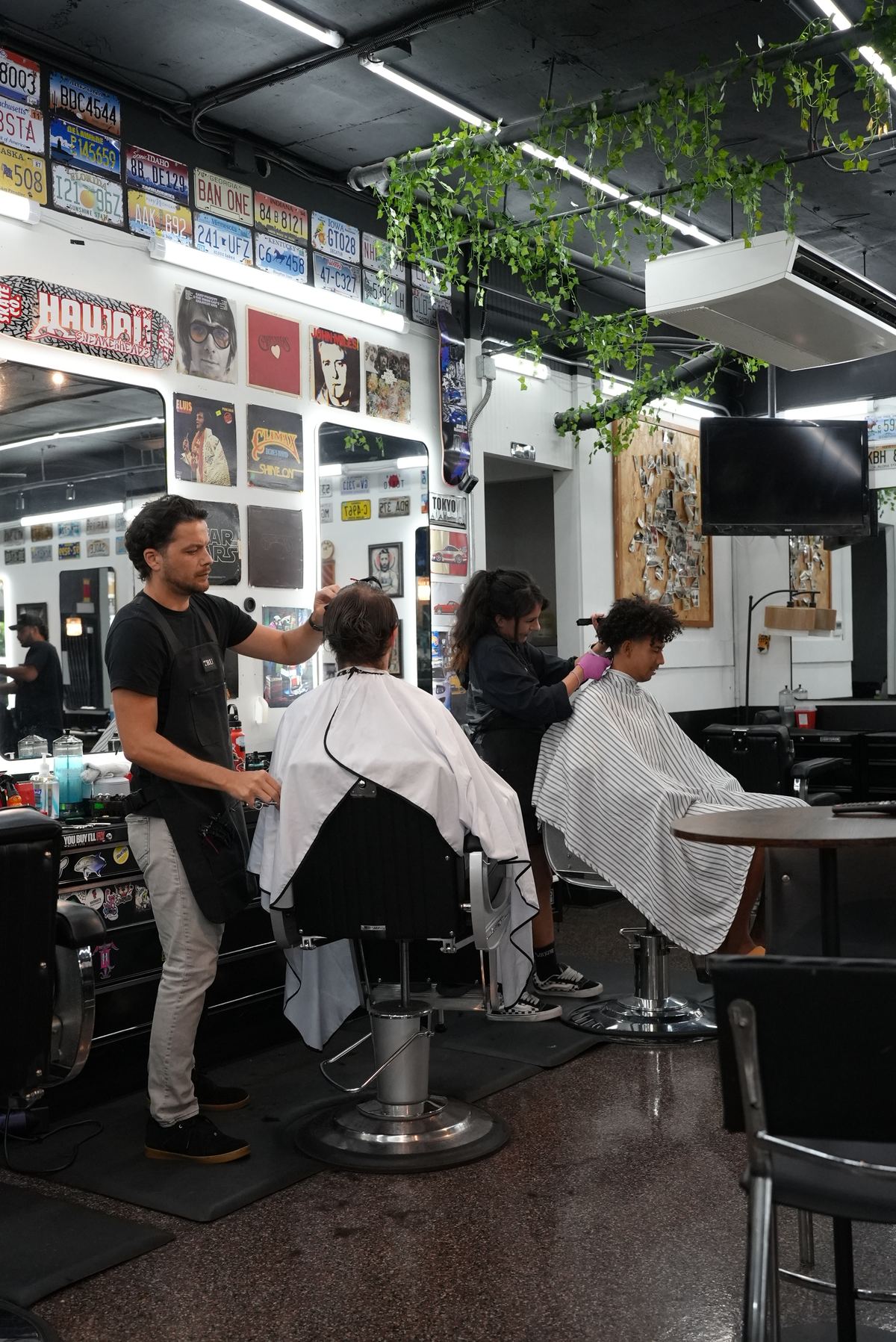 Action shot of barbers cutting hair inside Vintage Barbershop Bar and Coffee in Downtown Honolulu