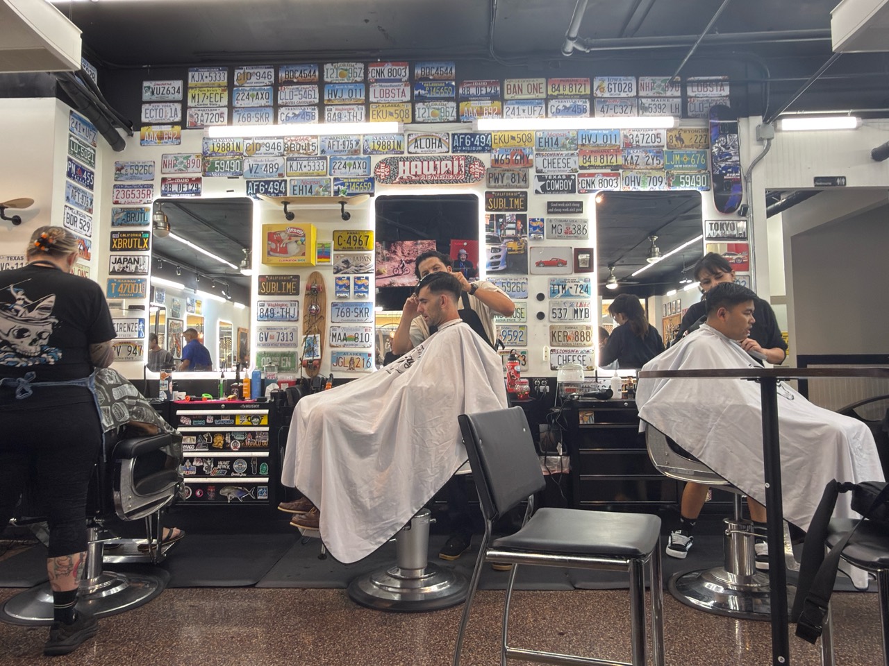Busy Honolulu barbershop with multiple barbers cutting hair at Vintage Barbershop