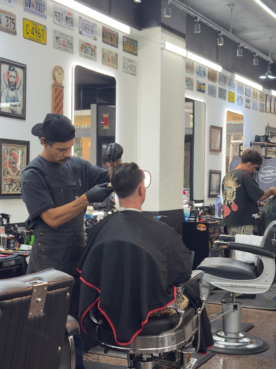 Barber cutting hair inside Vintage Barbershop Honolulu